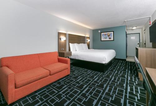a hotel room with a bed and a couch at Baymont by Wyndham Chattanooga Eastridge in East Ridge