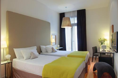 a hotel room with two beds with yellow sheets at Esplendor by Wyndham Montevideo Cervantes in Montevideo