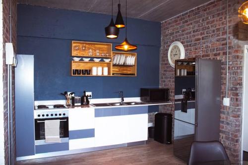 a kitchen with a stove and a blue wall at Swift Studios No4 in Cape Town