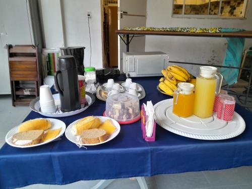une table bleue avec des plaques alimentaires et du jus d'orange dans l'établissement Pousada CNU, à Rio de Janeiro