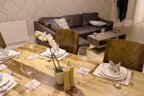 a dining room table with plates and wine glasses at Apartment in West Yorkshire in Keighley