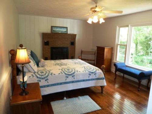 ein Schlafzimmer mit einem Bett und einem Tisch mit einer Lampe in der Unterkunft Light Of The Valley River House in Woodstock