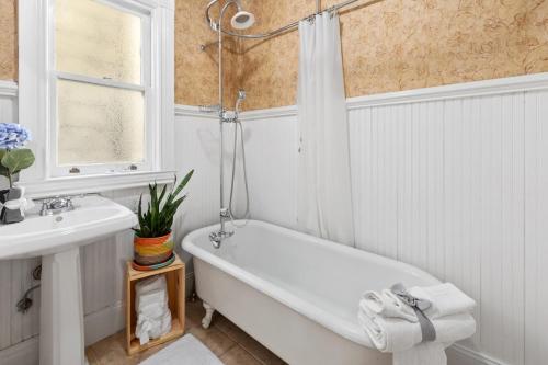 a white bathroom with a tub and a sink at Gorgeous Victorian Flat in San Francisco