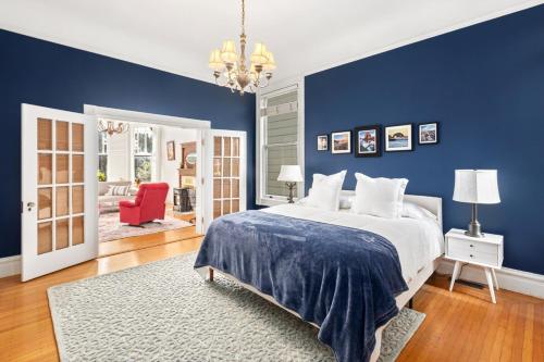 a blue bedroom with a bed and a red chair at Gorgeous Victorian Flat in San Francisco