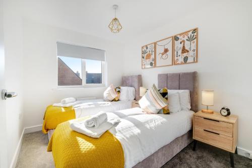 a bedroom with two beds and a window at Modern 5 Bedroom 3 Bathroom Serviced House Aylesbury with Parking By 360Stays in Aylesbury
