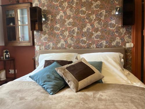 a bedroom with a bed with pillows and a wall at B&B Vassy Etaule in Avallon