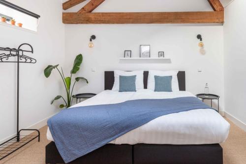 een slaapkamer met een groot bed met blauwe kussens bij Boetiek hotel Azul in Goedereede