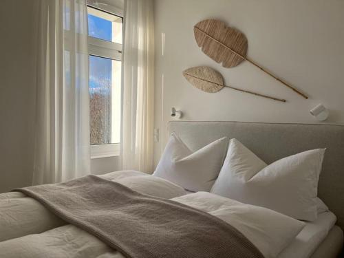 a bedroom with a bed with white sheets and a window at Wohlfühl-Apartment am Paradiesberg in Radebeul