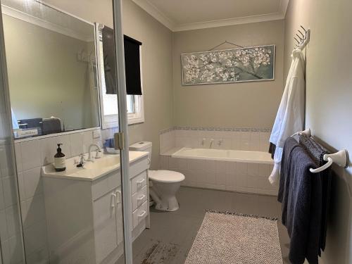 a bathroom with a tub and a toilet and a sink at Bush Retreat Farm Stay 2 BR in Gelliondale