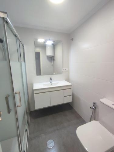 a white bathroom with a sink and a shower at Alta Vista - apartamento con 2 dormitorios y vista al mar in Torrevieja