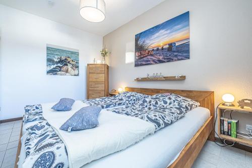ein Schlafzimmer mit einem Bett und einem Gemälde an der Wand in der Unterkunft Ferienwohnungen im Haus Strandburg Grömitz in Grömitz