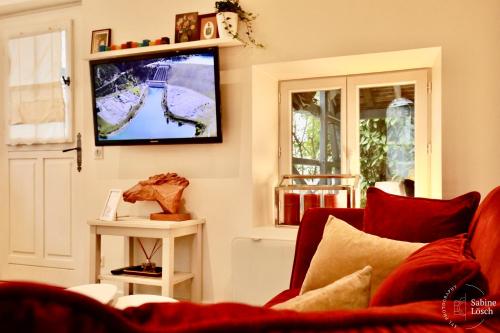 a living room with a couch and a tv on the wall at Chez Marcel in Le Vaudreuil