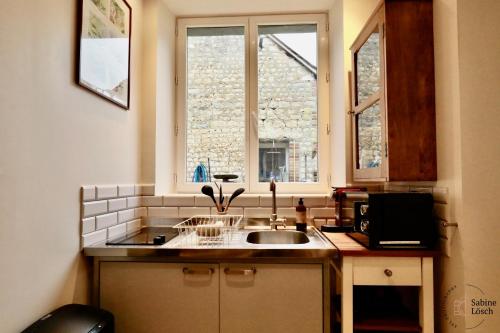 a kitchen with a sink and a window at Chez Marcel in Le Vaudreuil