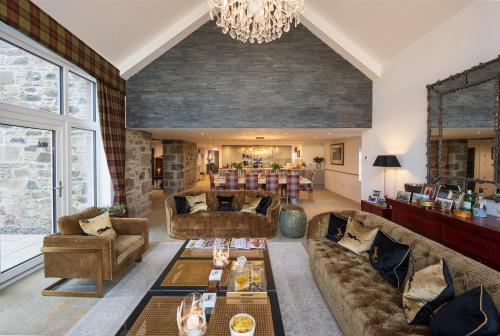a living room with couches and a dining room at Kipney Farmhouse - luxury hunting lodge in Perth
