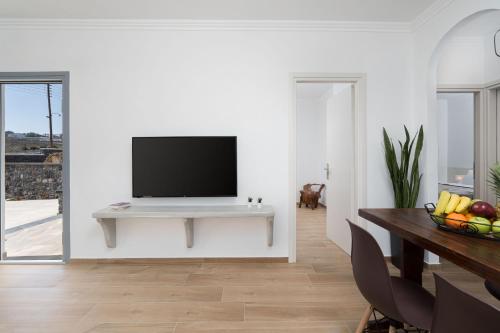a living room with a tv on a white wall at Bliss Holidays Spot in Fira