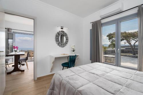 a bedroom with a bed and a table with a desk at Bliss Holidays Spot in Fira