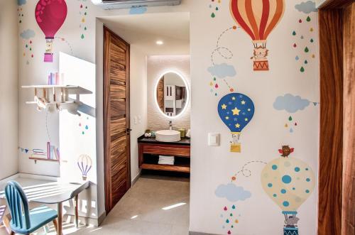 a room with a table and balloons on the wall at Palmaïa The House of AïA All Inclusive Wellness Resort in Playa del Carmen