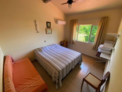 1 dormitorio con cama y ventana. en Casa da Vovó, en Itapema