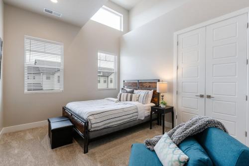 a bedroom with a bed and a blue couch at Ocotillo 69 3 Bedrooms with a Private Hot Tub, Fire Pit, and Private Patio in Santa Clara