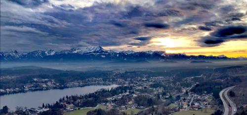 a view of a city and a lake and mountains at Haus der Geschenke - Carinthia in Velden am Wörthersee
