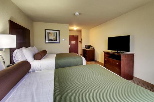 a hotel room with two beds and a flat screen tv at Cobblestone Hotel & Suites - Waynesboro in Rouzerville