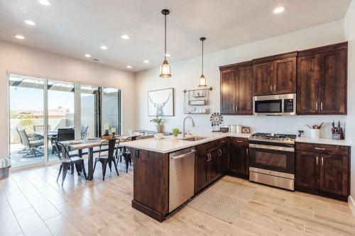 a kitchen with wooden cabinets and a table with chairs at Ocotillo 70 Red Mountain View Resort, Private Pool & Hot Tub in Santa Clara