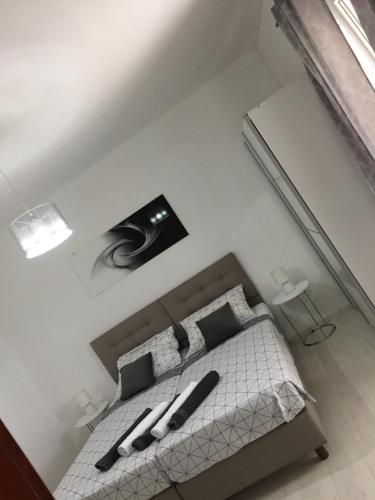 - une chambre blanche avec un lit et des oreillers noirs dans l'établissement Angelo 2, à Bibinje