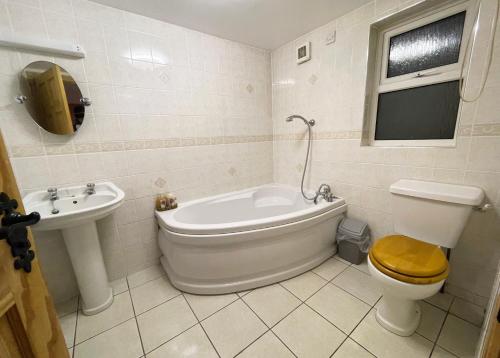 uma casa de banho com uma banheira, um WC e um lavatório. em Main Street Cottage, Ballintoy em Ballintoy