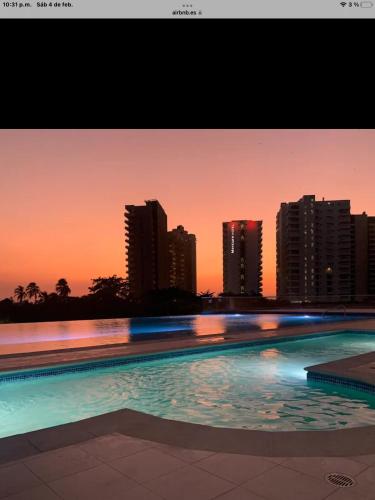 einen Pool mit einer Skyline der Stadt im Hintergrund in der Unterkunft Sensacional moderno , Bello Horizonte sector Irotama , Zazue in Santa Marta