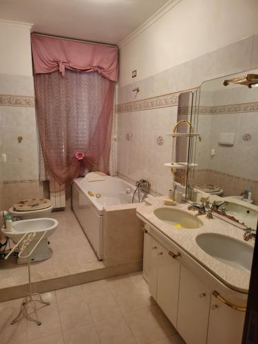 Un baño con dos lavabos, una bañera y un inodoro. en Fiumicino River, en Fiumicino