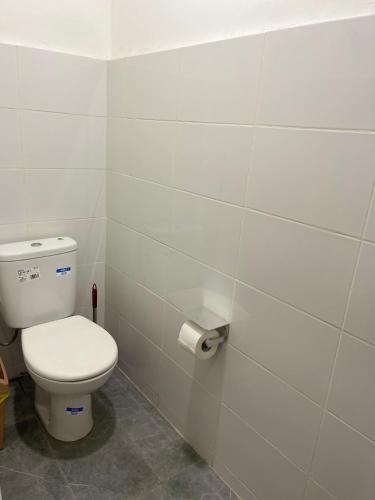 a bathroom with a toilet and a roll of toilet paper at American mall in Accra