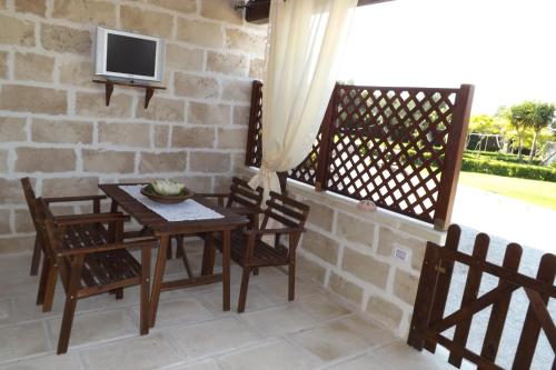 een patio met een tafel en stoelen en een televisie bij L'Antico Casale in Galatone