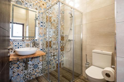 a bathroom with a shower and a toilet and a sink at Narcisa - Luxury 3BR Traditional House with Pool, Cinema & Hot Tub in Tal-Barmil