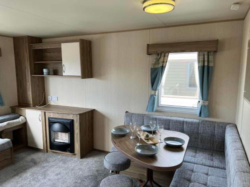 a living room with a table and a couch at Withersea Sand Holiday Home in Withernsea