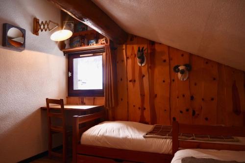 a bedroom with two beds in a room with wooden walls at VAL D'ISERE - 2 Bedroom Apartment & Private Parking in La Daille