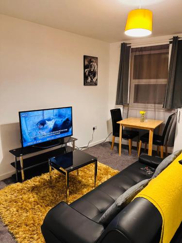- un salon avec un canapé et une télévision dans l'établissement City Blessed Apartment 1 with free parking, à North Shields