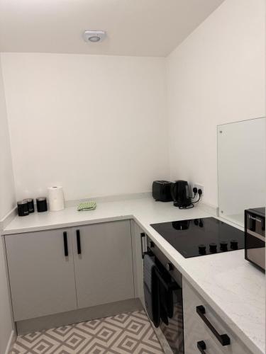 a kitchen with white cabinets and a stove top oven at City Blessed Apartment 1 with free parking in North Shields
