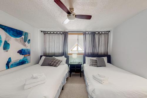 sypialnia z 2 łóżkami i wentylatorem sufitowym w obiekcie Chateau Ridge 223 w mieście Blue Mountains