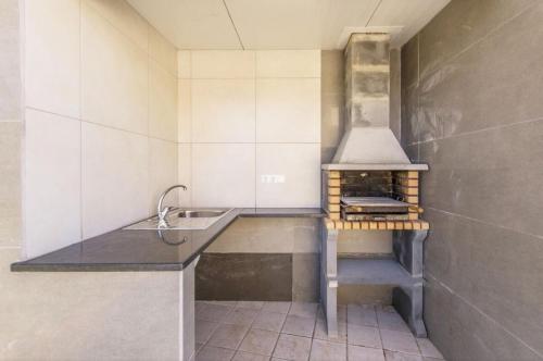 a kitchen with a sink and a stove at Villa Saudade in Lagoa