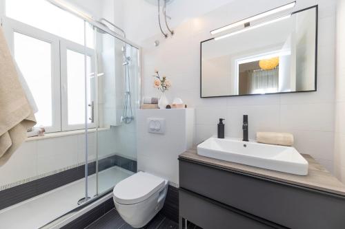 y baño con lavabo, aseo y espejo. en Apartments & Rooms Kolovare Beach en Zadar