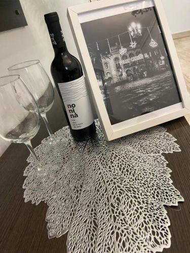 a bottle of wine next to a picture and a wine glass at Casa Mina Cadiz in Cádiz