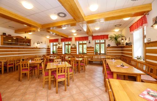 Svycarska Bouda في سبيندلروف ملين: غرفة طعام مع طاولات وكراسي خشبية