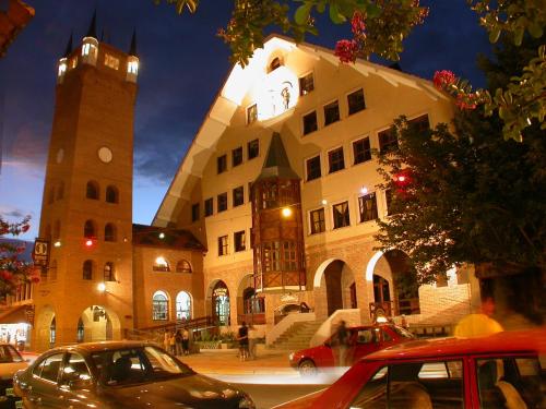 a large building with a clock tower in front of it at Howard Johnson Hotel & Spa Villa General Belgrano in Villa General Belgrano