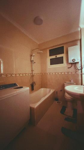 La salle de bains est pourvue d'une baignoire, de toilettes et d'un lavabo. dans l'établissement Restful and trendy apartment in 6 October city Cairo, à Ville du 6 Octobre