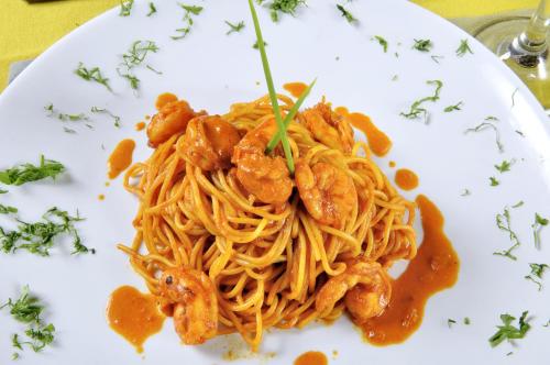 a plate of shrimp pasta with sauce on a table at Vichayito Bungalows & Carpas by Aranwa Hotels in Vichayito