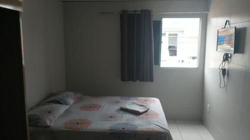 um pequeno quarto com uma cama e uma janela em STUDIO Ponta Verde em Maceió