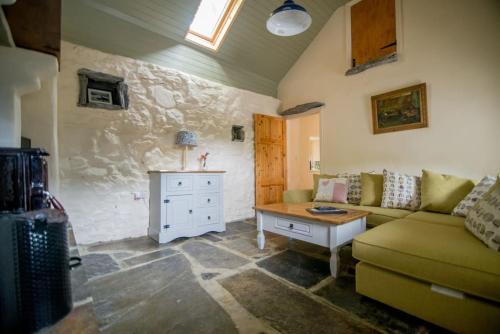 un soggiorno con divano e tavolo di Carleys Cottage a Fanore