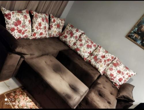 a brown couch with pillows on top of it at LUZ DO LUAR in Pedra Azul