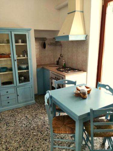 a kitchen with a blue table and chairs at Masseria Trulli sull'Aia in Cisternino