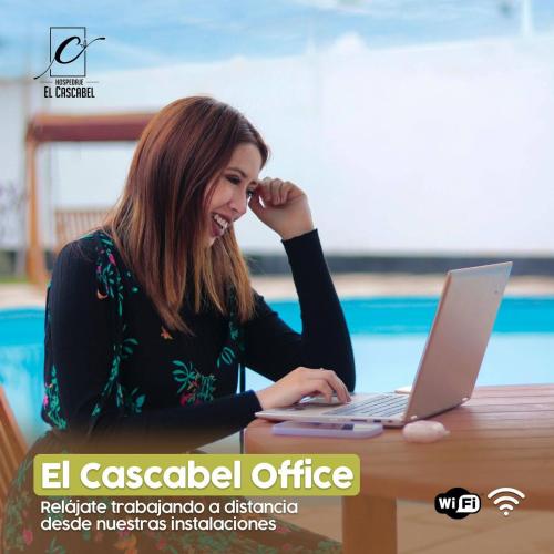 a woman sitting at a table with a laptop computer at Hospedaje El Cascabel in Sunampe